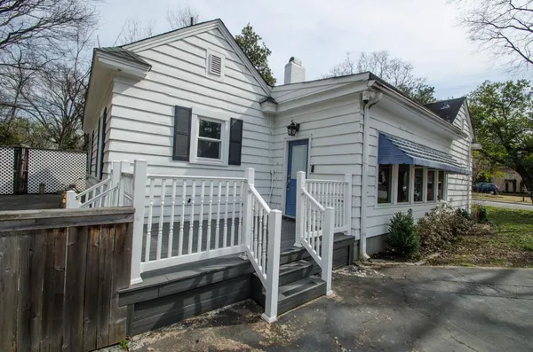 a view of a house with wooden fence and a large tree