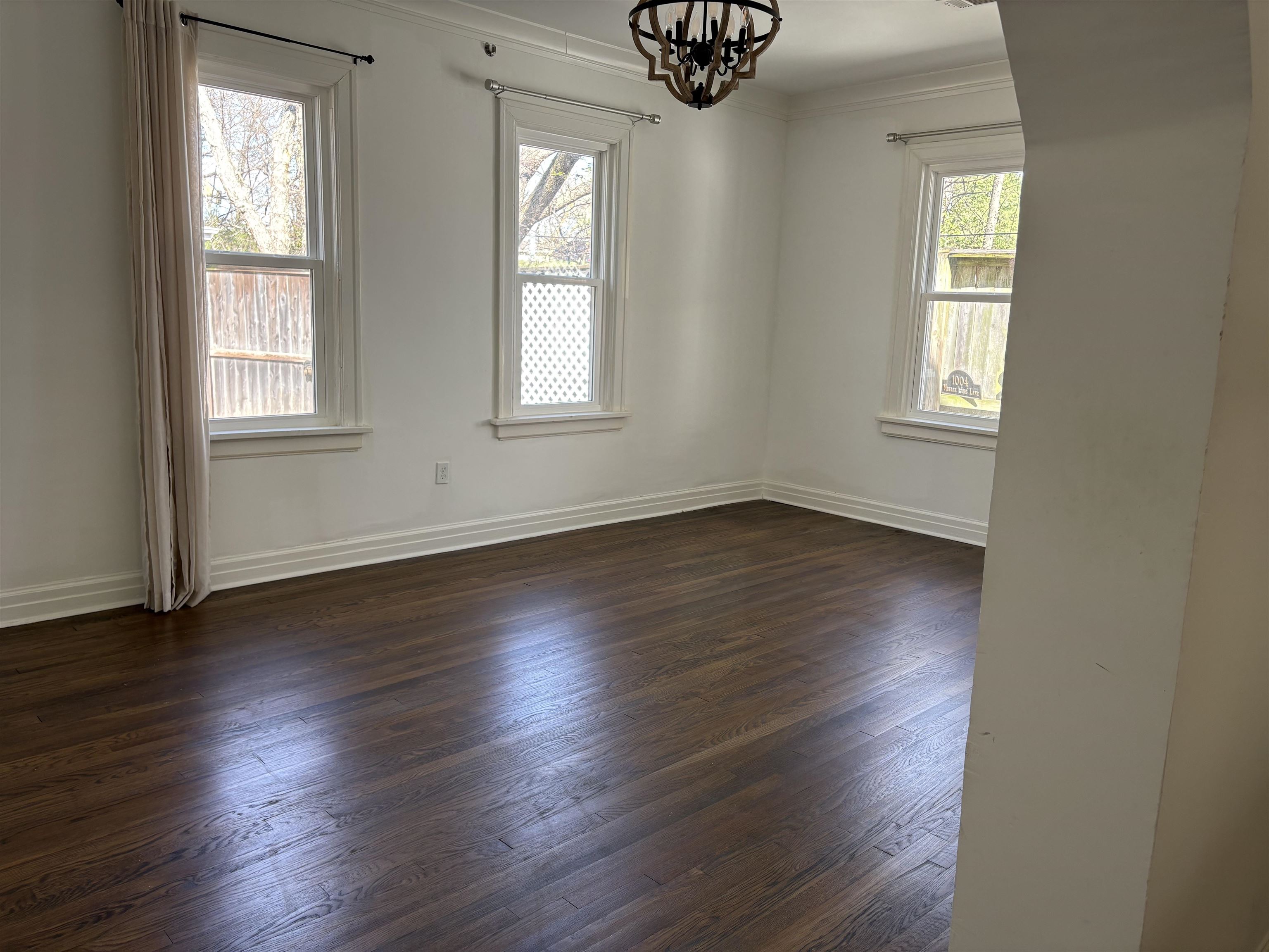 4572 Princeton Road Memphis, TN 38117 - Photo 7 of 24 Unfurnished room featuring hanging lights, dark wood-style floors, and ornamental molding