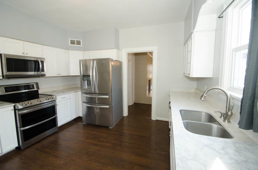 4572 Princeton Road Memphis, TN 38117 - Photo 9 of 24 Kitchen featuring stainless steel appliances, light stone counters, and white cabinetry