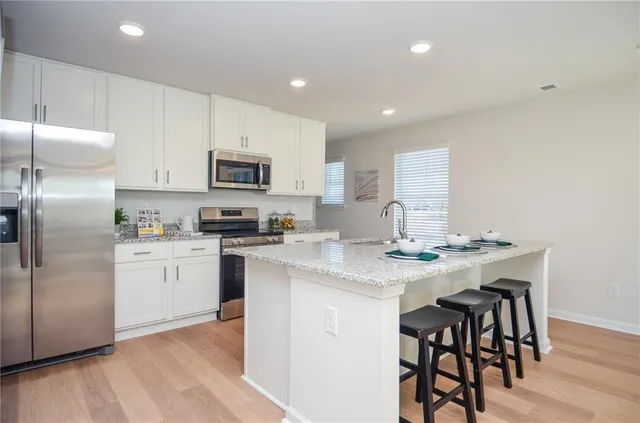 a kitchen with a sink stainless steel appliances and white cabinets