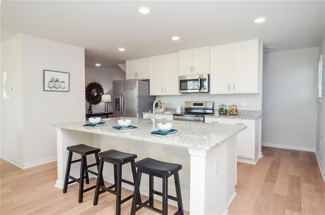 a kitchen with a dining table chairs and cabinets