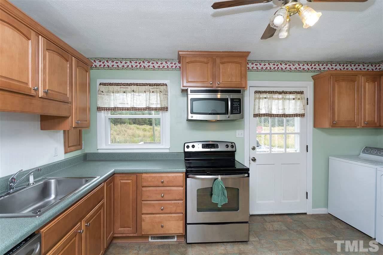 3315 Zacks Mill Road, Unit C Angier, NC 27501 - Photo 4 of 25 a kitchen with stainless steel appliances kitchen island granite countertop a stove a sink and a microwave
