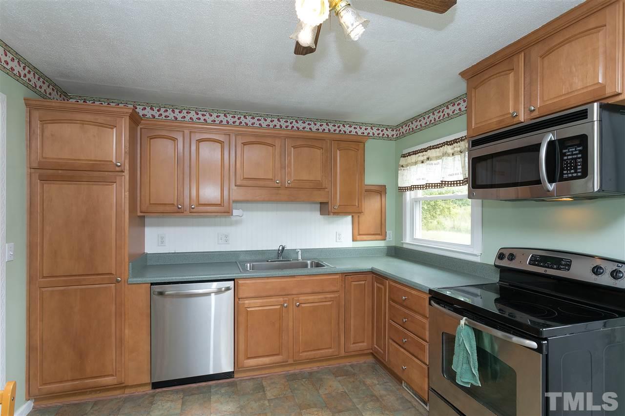 3315 Zacks Mill Road, Unit C Angier, NC 27501 - Photo 8 of 25 a kitchen with granite countertop a refrigerator stove top oven a sink and dishwasher