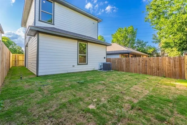 a view of a backyard with plants and large tree