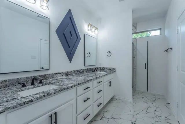 a bathroom with a granite countertop sink vanity and mirror