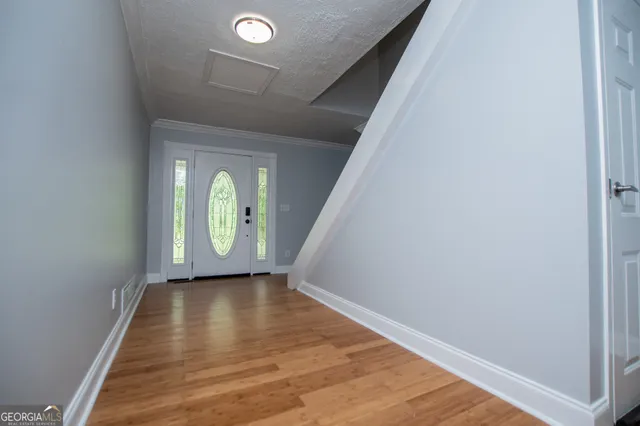 an empty room with wooden floor chandelier fan and windows