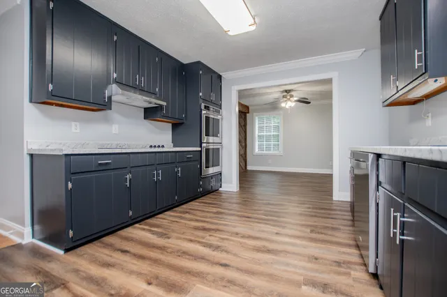 a kitchen with stainless steel appliances granite countertop a sink stove and cabinets