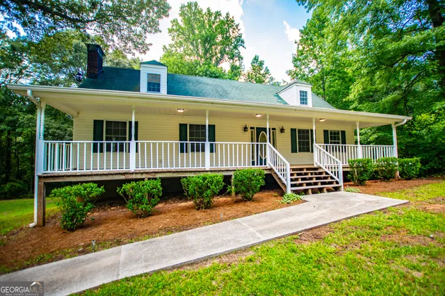 a view of a house with a yard and sitting area