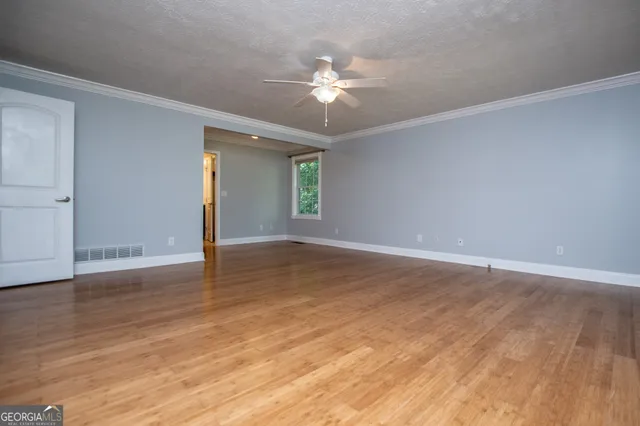 a view of an empty room with wooden floor
