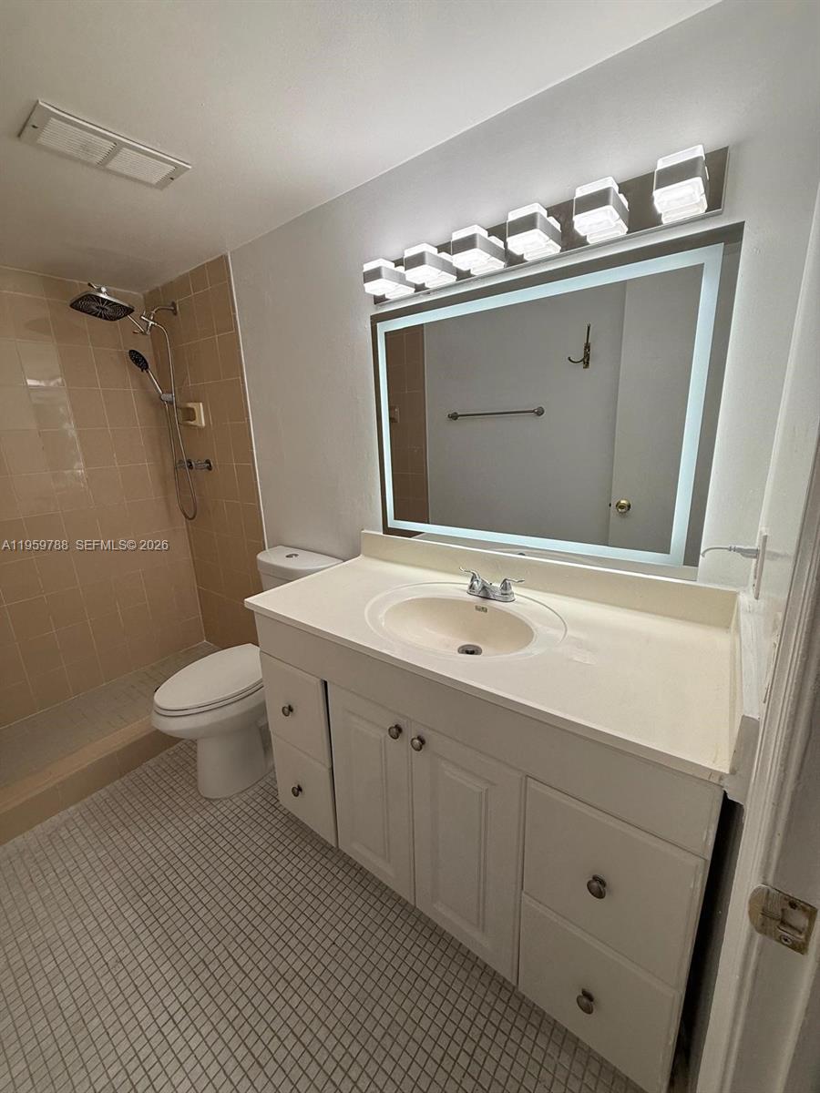 9520 Southwest 8th Street, Unit 111 Miami, FL 33174 - Photo 17 of 31 a bathroom with a double vanity sink mirror and toilet
