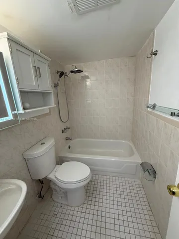 a bathroom with a granite countertop toilet a sink and a bathtub