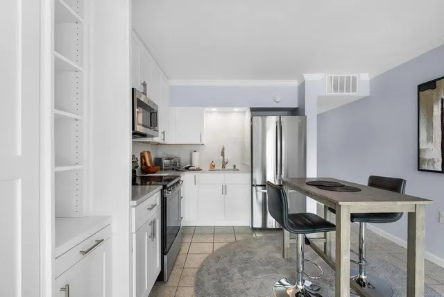 a kitchen with stainless steel appliances granite countertop a stove refrigerator sink and cabinets