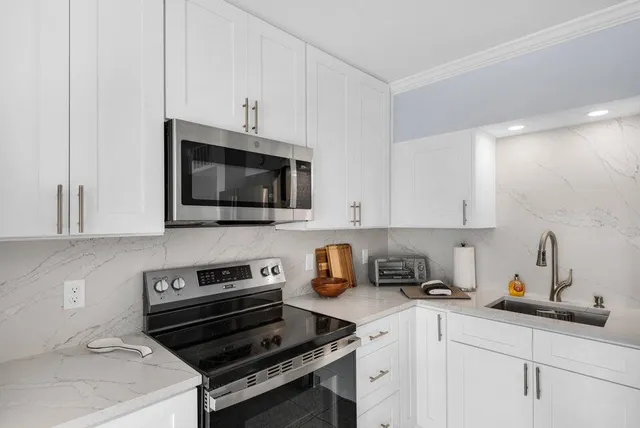 a kitchen with a sink and white cabinets