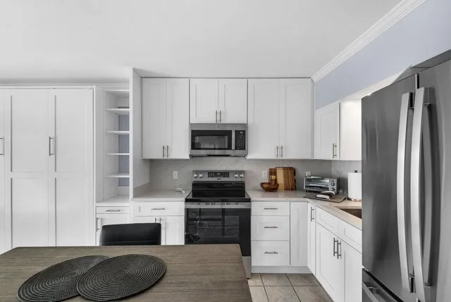 a kitchen with stainless steel appliances granite countertop a refrigerator sink and stove