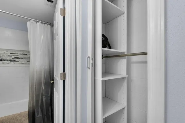 a view of walk in closet with empty racks