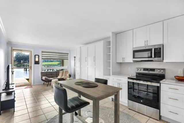 a kitchen with stainless steel appliances kitchen island granite countertop a stove a sink and a refrigerator