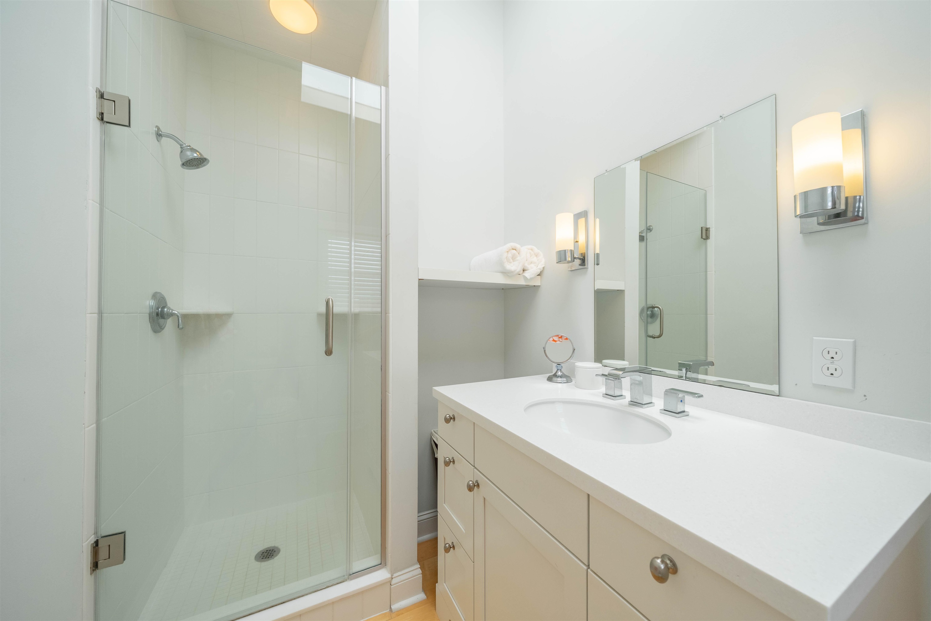 25 9th Street Avalon, NJ 08202 - Photo 13 of 32 a bathroom with a shower sink vanity and mirror