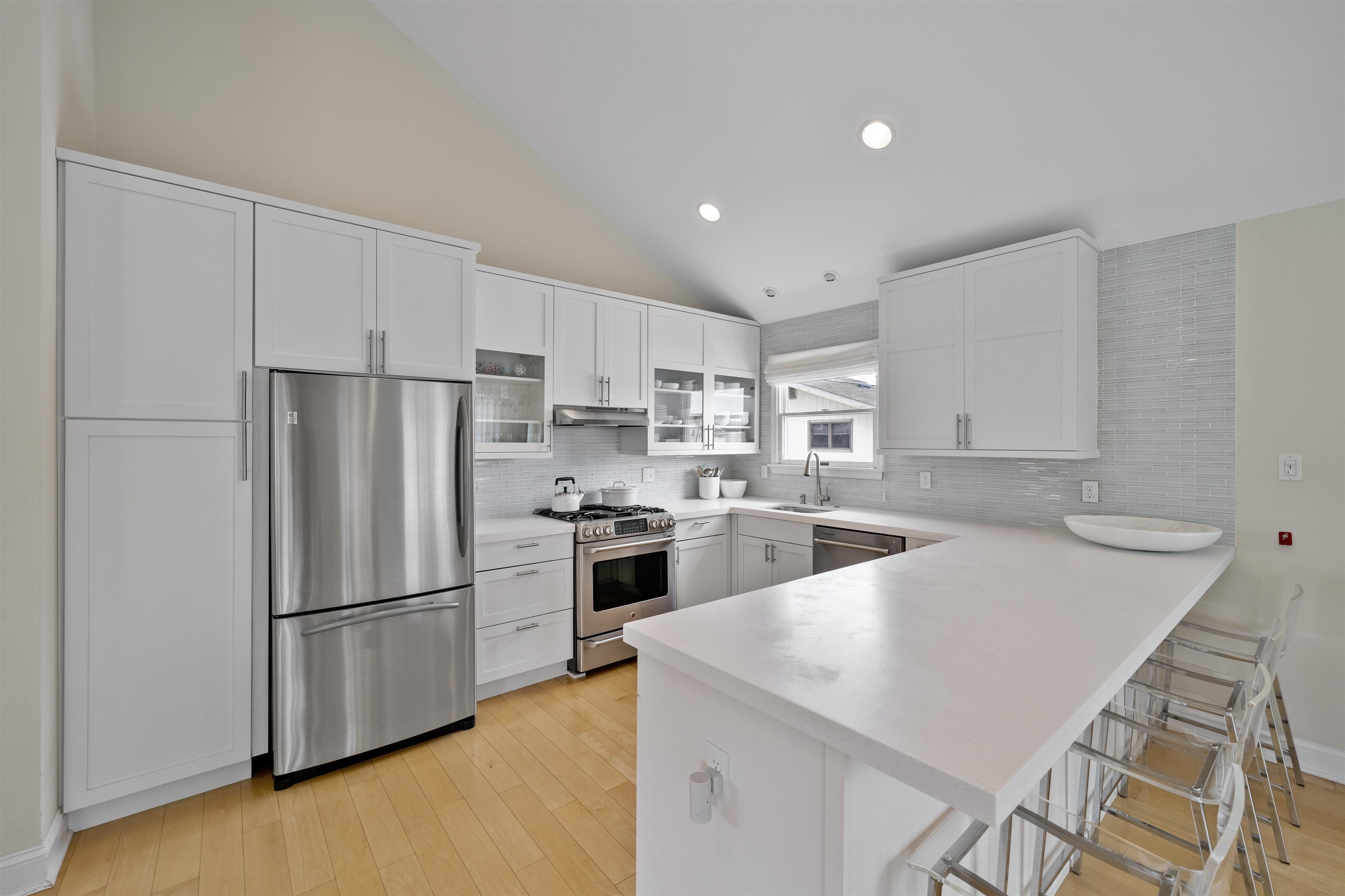 25 9th Street Avalon, NJ 08202 - Photo 7 of 32 a kitchen with white cabinets and stainless steel appliances