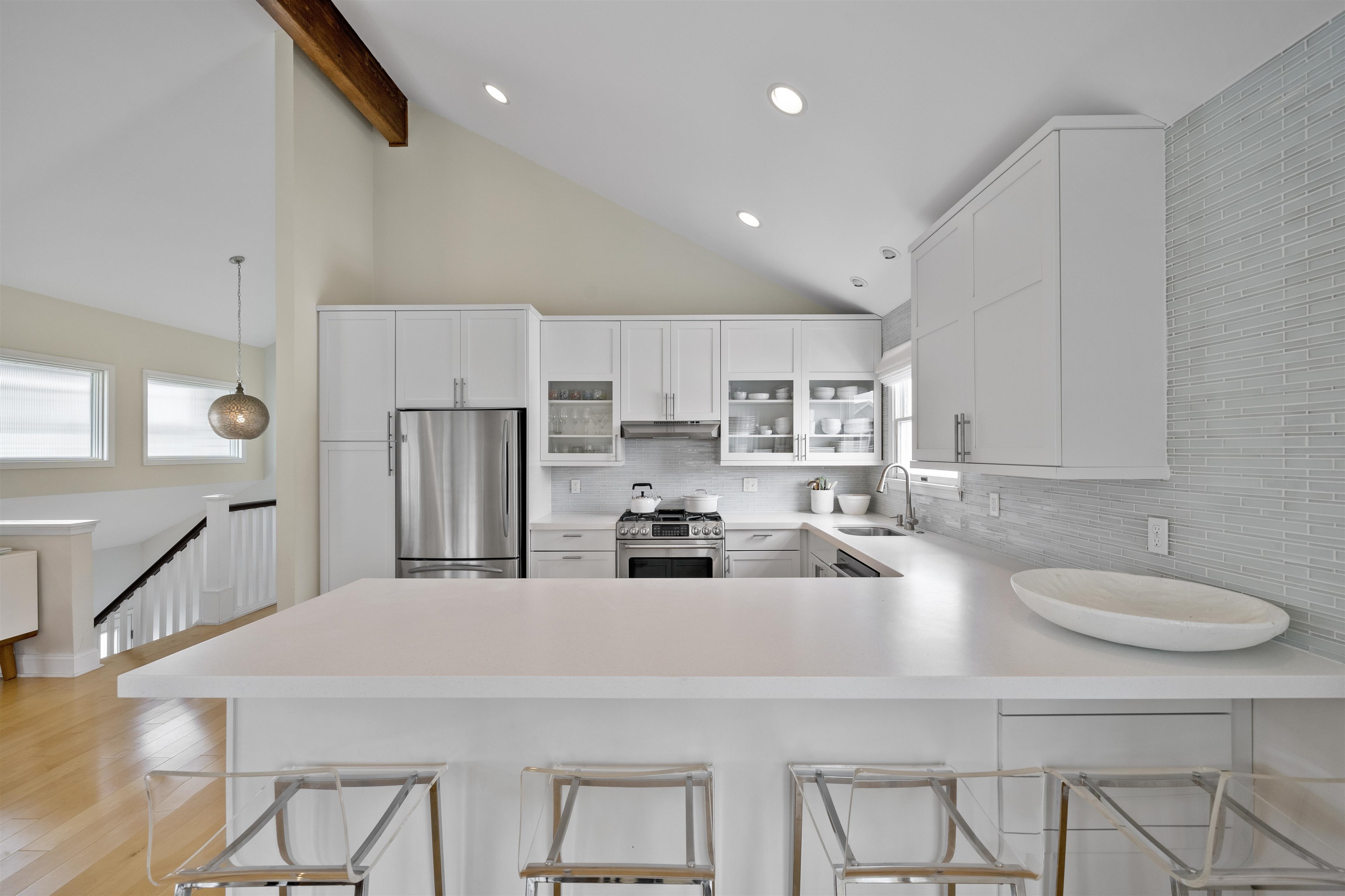 25 9th Street Avalon, NJ 08202 - Photo 9 of 32 a kitchen with stainless steel appliances a sink a stove a microwave a center island and chairs