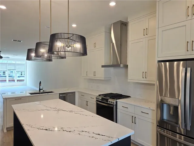 a kitchen with stainless steel appliances granite countertop a sink stove and refrigerator