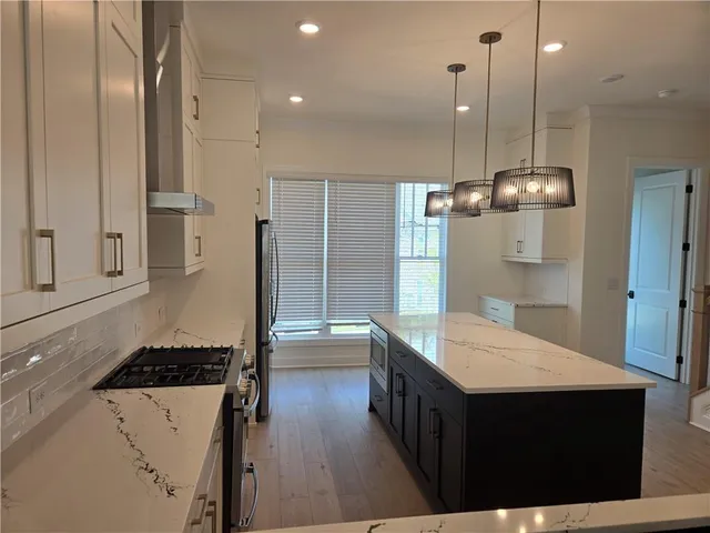 a kitchen with a refrigerator a sink and wooden floor