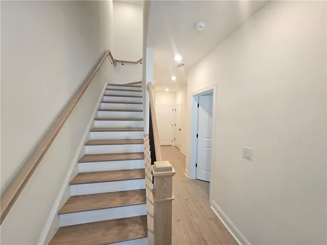 a view of a hallway with wooden floor and entryway