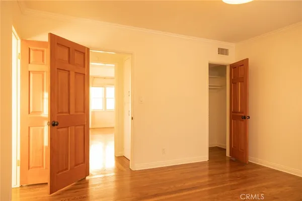 a view of empty room with wooden floor