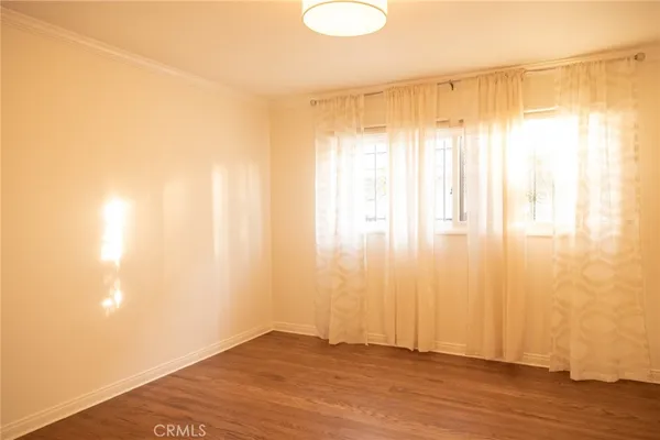 a view of a livingroom with wooden floor and a window