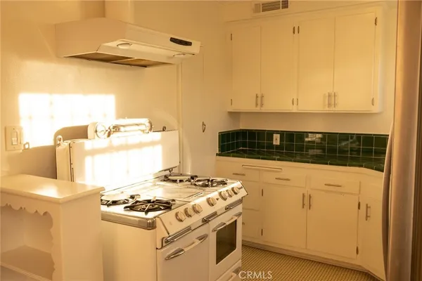 a kitchen with a stove and a white cabinet