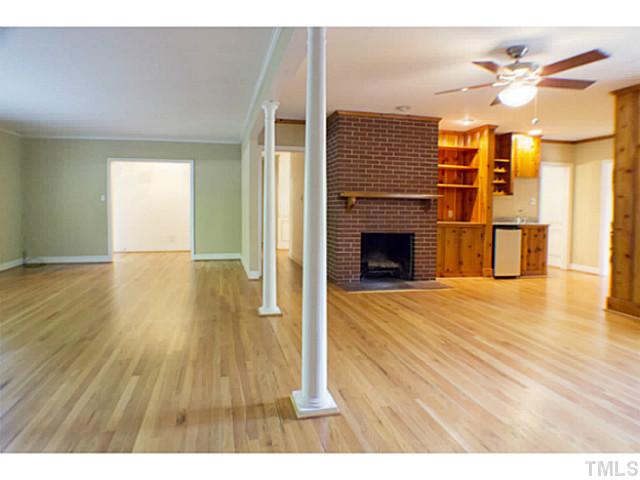 3105 Churchill Road Raleigh, NC 27607 - Photo 9 of 16 a view of empty room with wooden floor and fireplace