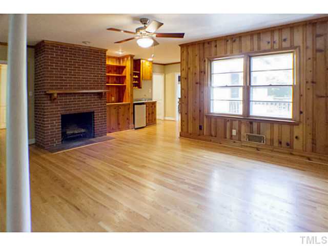 3105 Churchill Road Raleigh, NC 27607 - Photo 10 of 16 a view of an empty room with a fireplace and a window