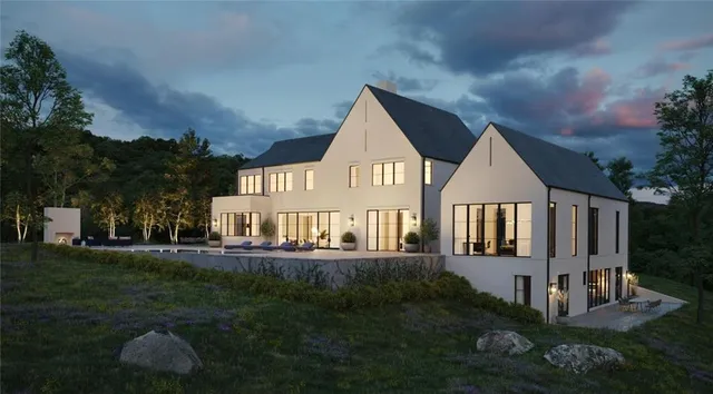 a view of a house next to a yard and large trees