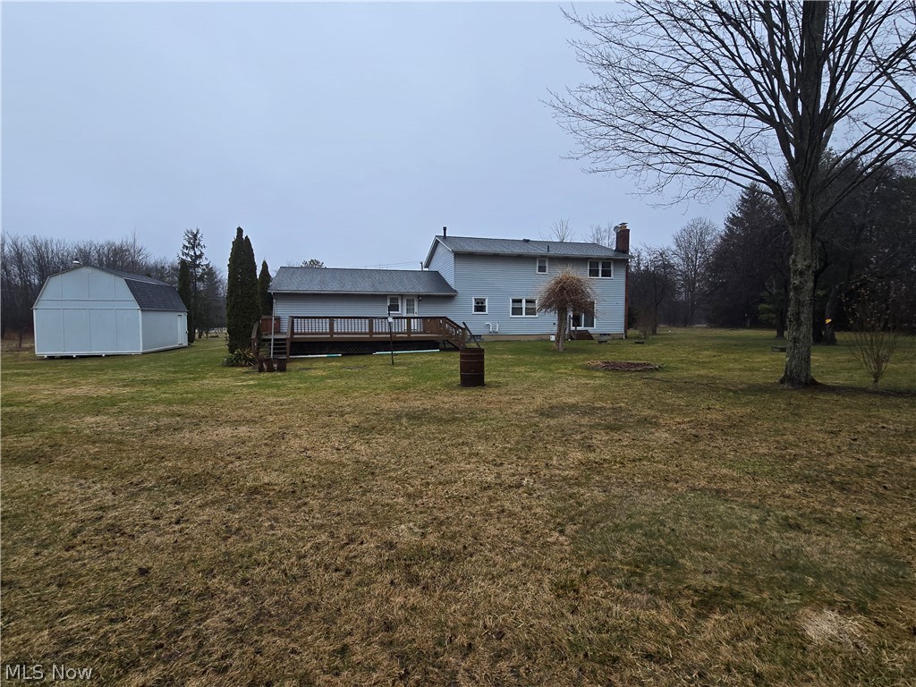 2672 Crackel Road Aurora, OH 44202 - Photo 12 of 38 Back of property featuring an outdoor structure, a lawn, a chimney, and a deck