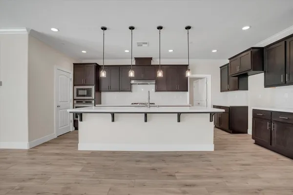 a view of kitchen with stainless steel appliances refrigerator stove microwave and cabinets