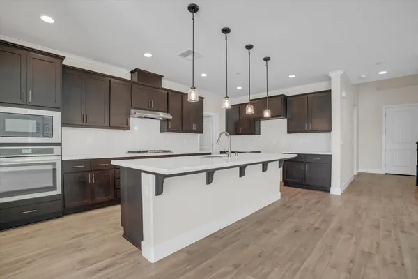 a kitchen with stainless steel appliances kitchen island a cabinets and wooden floor