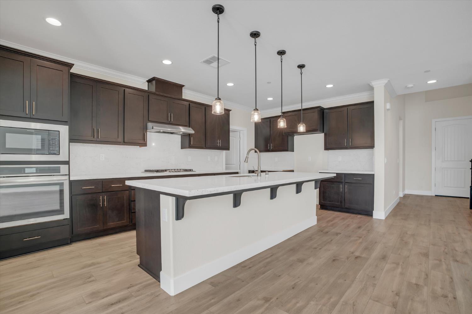 1898 Sanza Road Manteca, CA 95337 - Photo 12 of 41 a kitchen with stainless steel appliances kitchen island a cabinets and wooden floor