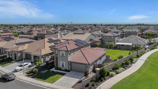 an aerial view of multiple houses with a yard