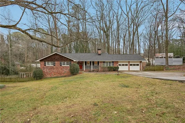 a view of a house with a yard and large tree