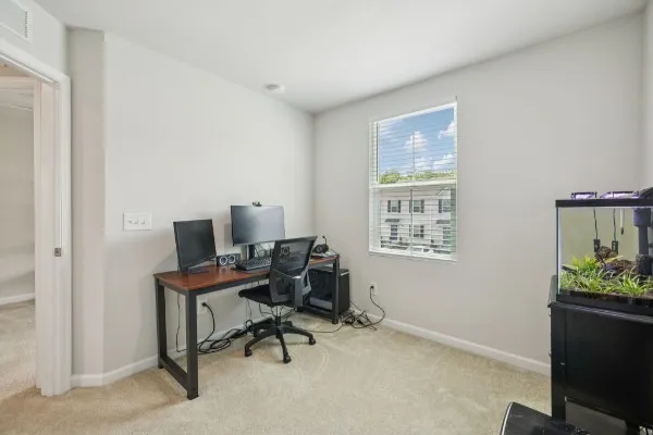a view of a workspace with furniture and a window