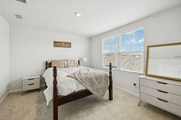 a bedroom with a bed and a window