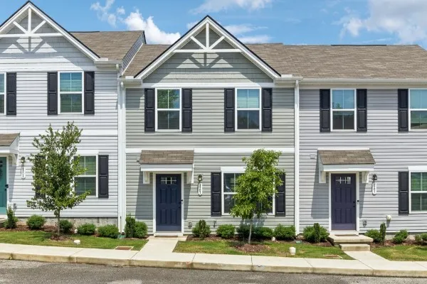 a front view of a house with a yard and potted plants