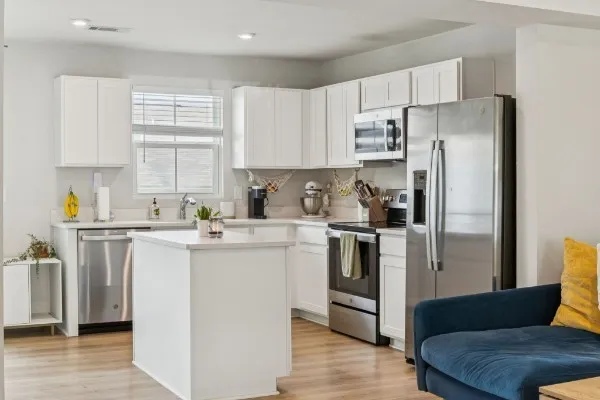 a kitchen with stainless steel appliances a refrigerator sink and cabinets
