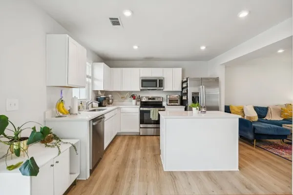 a kitchen with counter top space a sink cabinets and stainless steel appliances