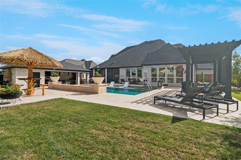 1920 Lotus Court Haslet, TX 76052 - Photo 28 of 40 Beautifully manicured grass and landscaping. Extra travertine decking for room to relax and move around the pool comfortably.