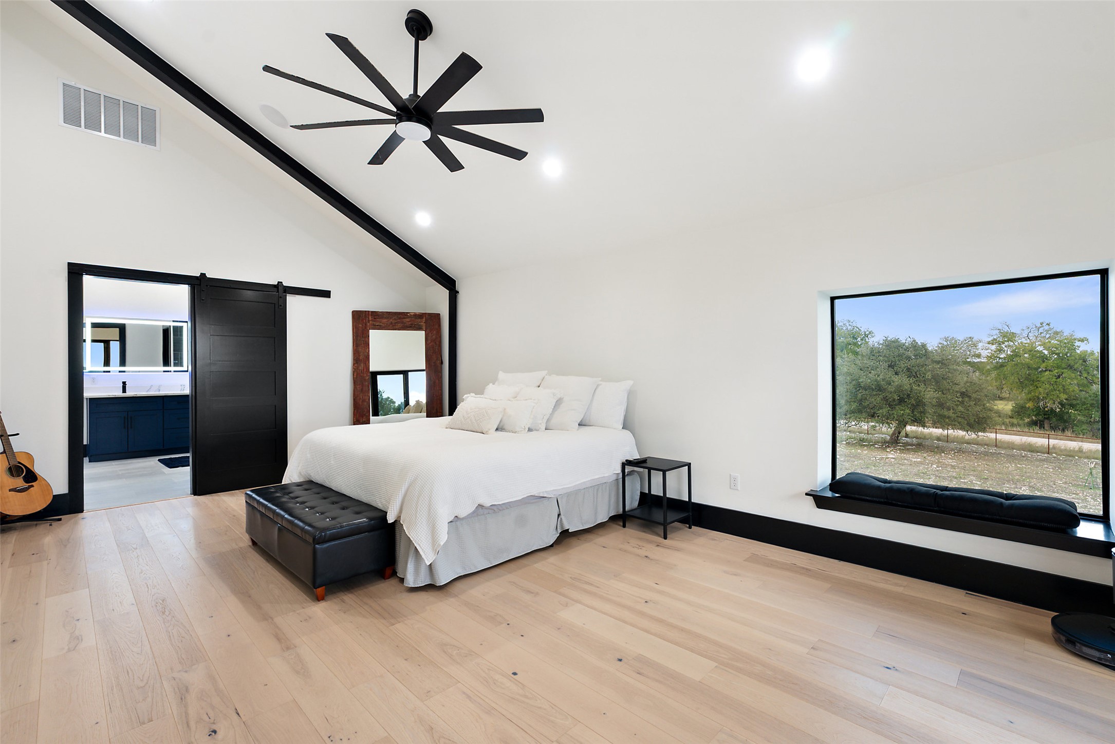 561 Broken Bit Trail Dripping Springs, TX 78620 - Photo 11 of 40 Bedroom with a barn door, light wood finished floors, high vaulted ceiling, recessed lighting, and a ceiling fan