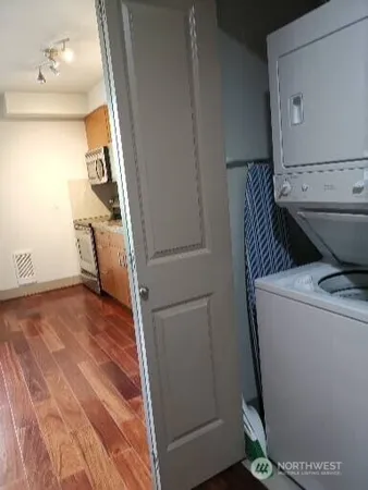 a kitchen with a refrigerator and wooden floor
