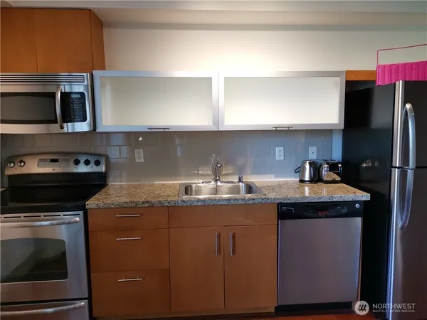 a kitchen with a sink cabinets and wooden floor