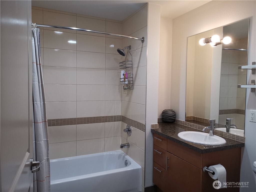 4547 8th Avenue Northeast, Unit 408 Seattle, WA 98105 - Photo 20 of 27 a bathroom with a granite countertop sink and a mirror