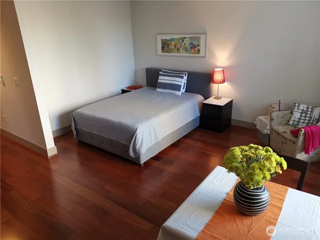 a bedroom with a bed and wooden floor