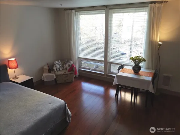 a bedroom with a bed and lamp on dresser